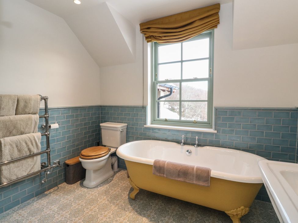 A bathroom with a bathtub, toilet, towel rack, and sink at Schiehallion House in Pitlochry