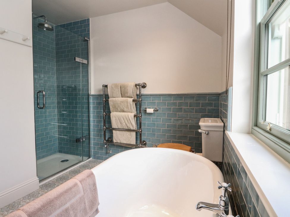 A bathroom with a bathtub, shower, and towel rack at Schiehallion House Pitlochry