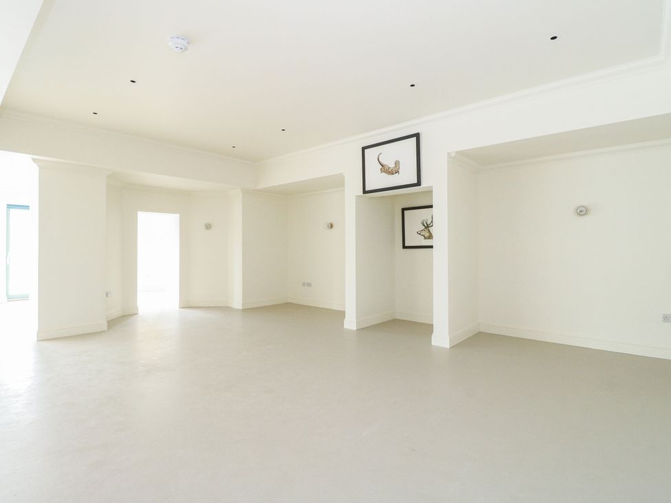 A living room with frames and a window at Schiehallion House in Pitlochry