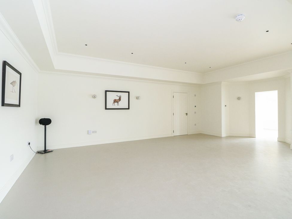 A living room with a lamp and paintings at Schiehallion House in Pitlochry