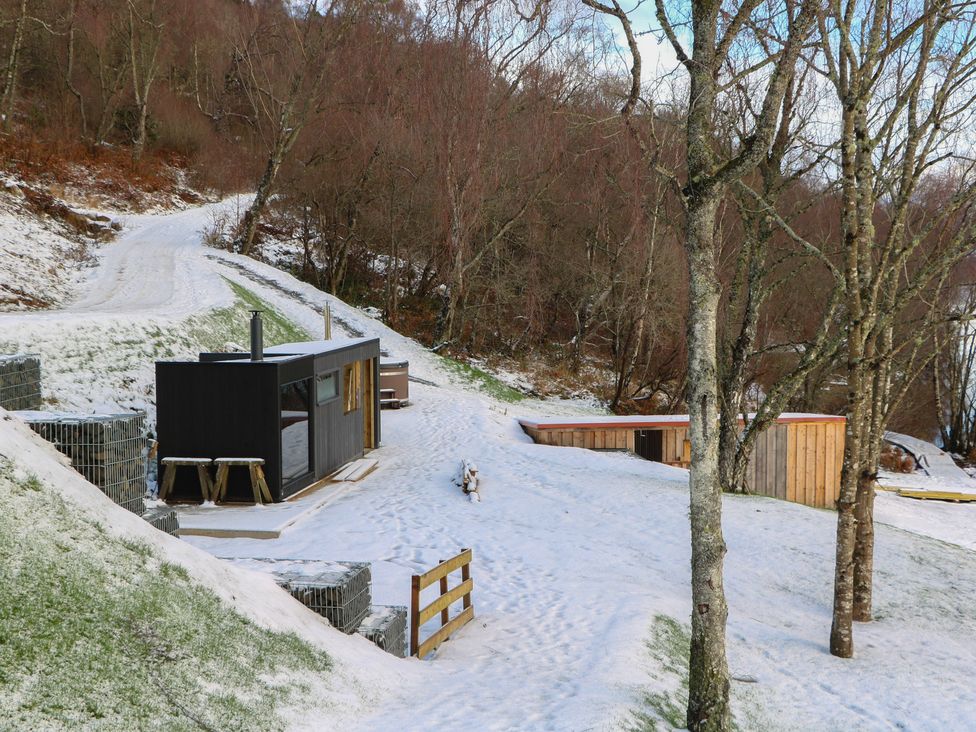 A snowy outdoor area with wooden buildings at Schiehallion House in Pitlochry