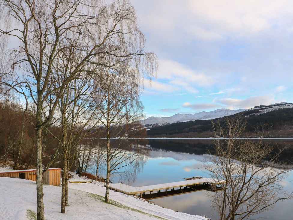 A lake with trees and a dock at Schiehallion House in Pitlochry