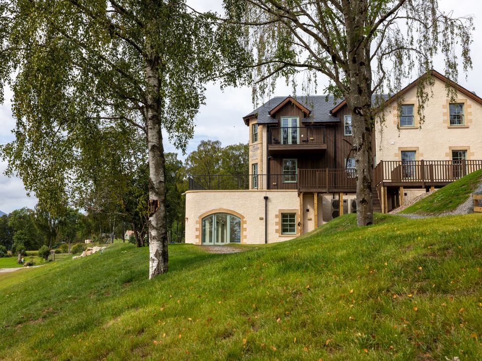 A house with a balcony and trees on the lawn at Schiehallion House in Pitlochry