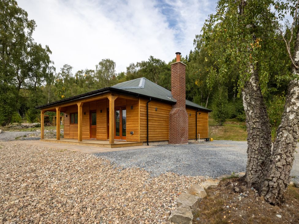 A log cabin with a chimney and windows at Schiehallion House in Pitlochry