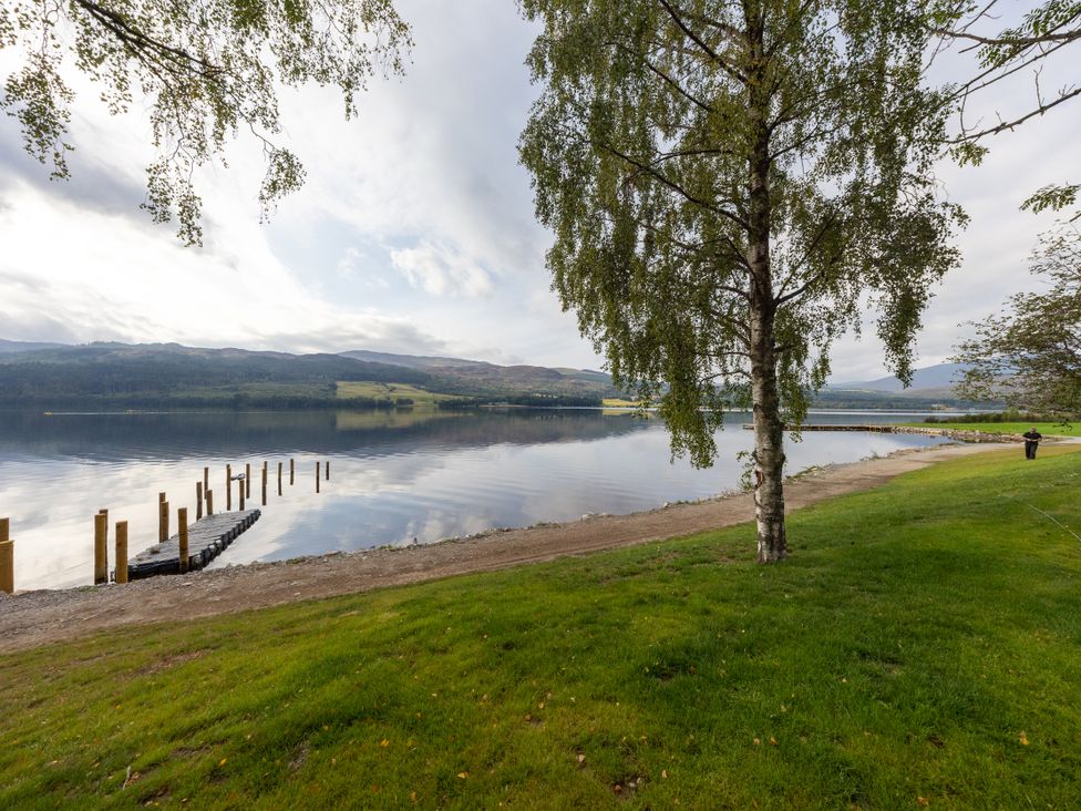 A scenic view of a lake with a tree and a pier at Schiehallion House in Pitlochry