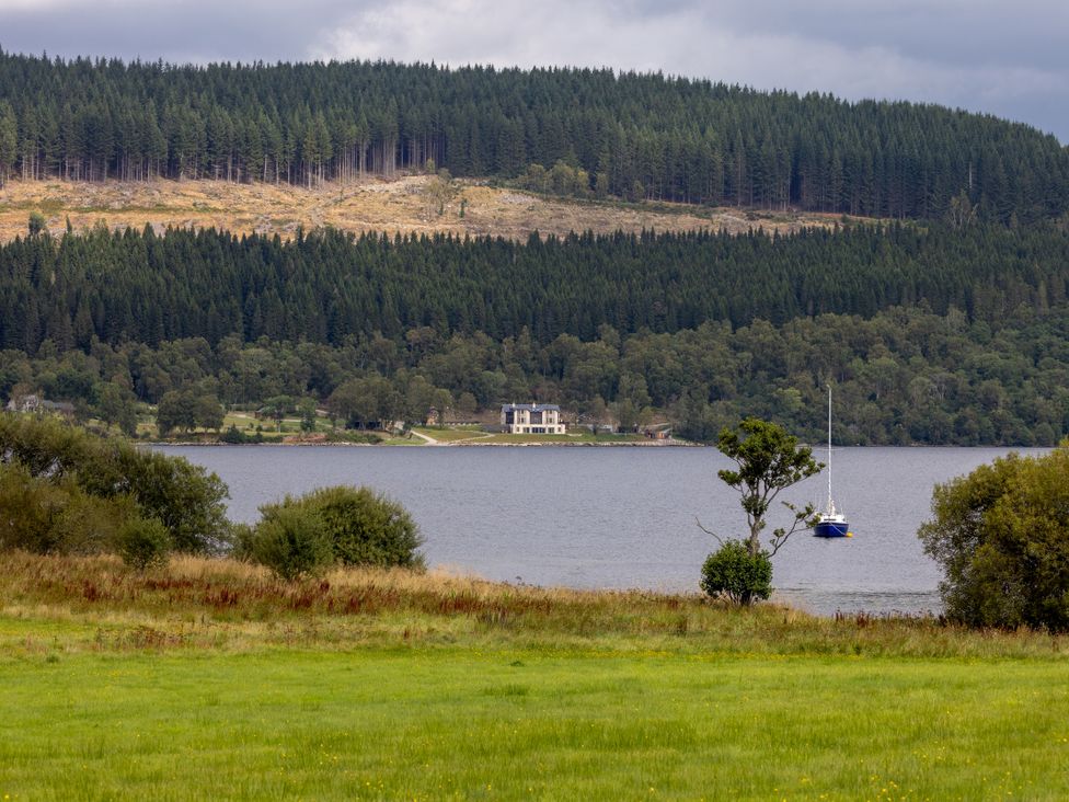 A house by a lake with forest and a boat at Schiehallion House in Pitlochry