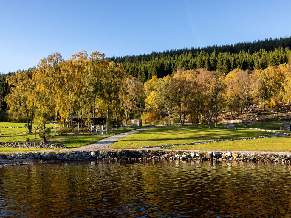 A view of trees and a pathway by the lake at Schiehallion House Pitlochry