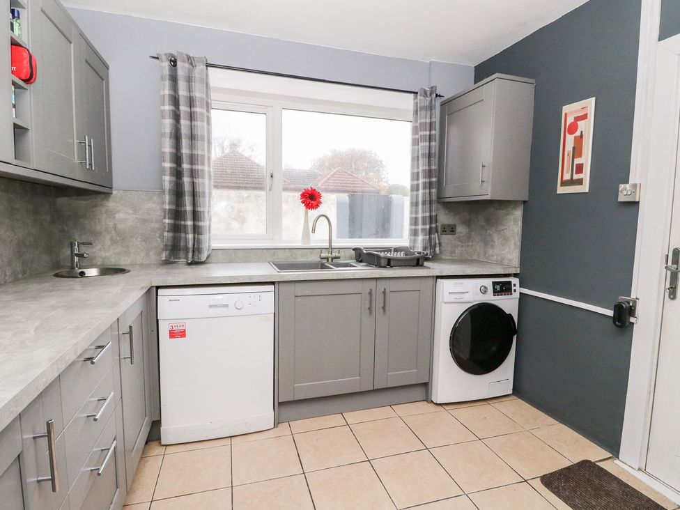 A kitchen with a sink, dishwasher, and washing machine at Seaview Wellness Retreat in Carnoustie