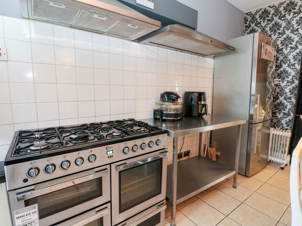 A kitchen with a stove, oven, countertop, and refrigerator at Seaview Wellness Retreat in Carnoustie