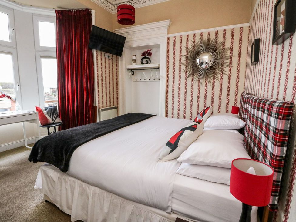 A bedroom with a bed, television, and desk at Seaview Wellness Retreat in Carnoustie