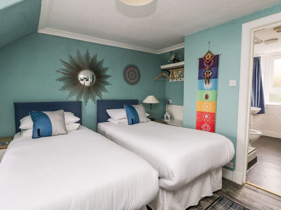 A bedroom with twin beds and wall decorations at Seaview Wellness Retreat in Carnoustie