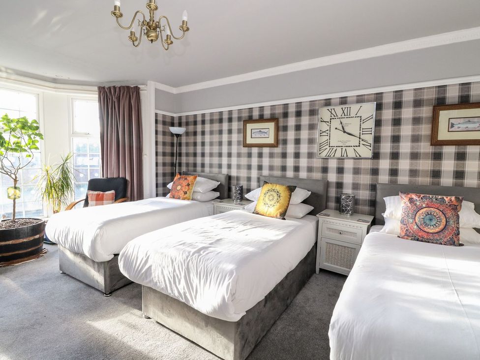 A bedroom with three beds and a large window at Seaview Wellness Retreat in Carnoustie