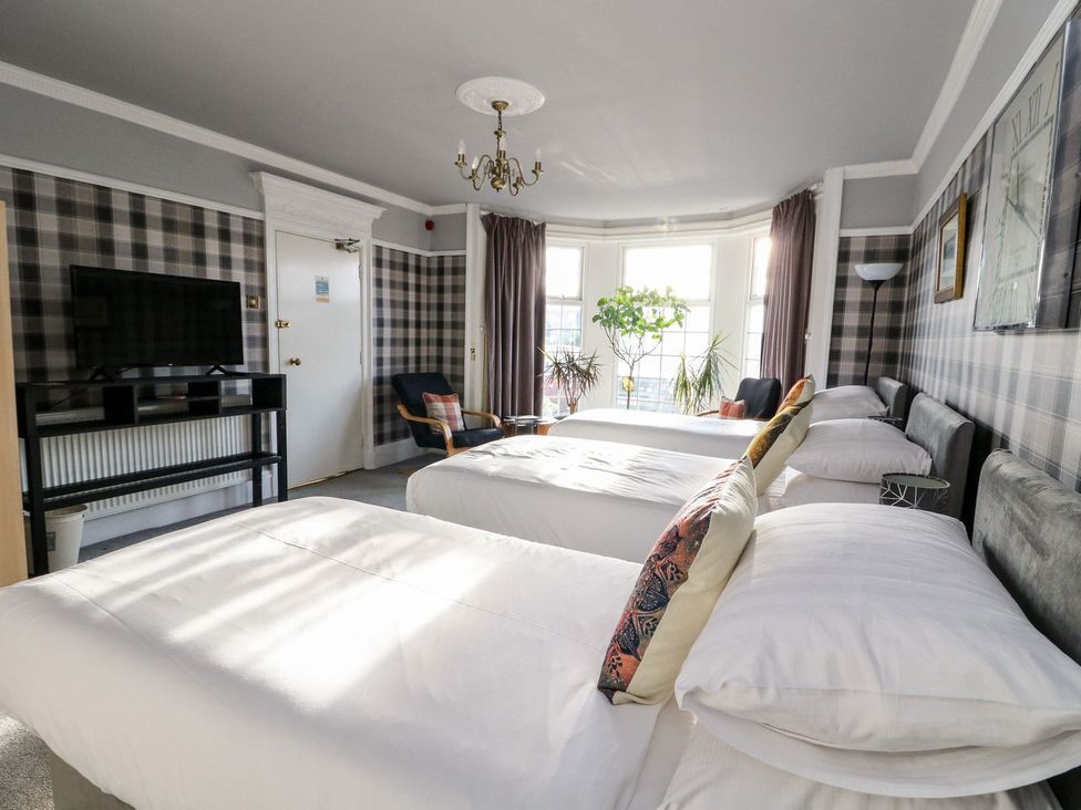 A bedroom with two beds and a television at Seaview Wellness Retreat in Carnoustie