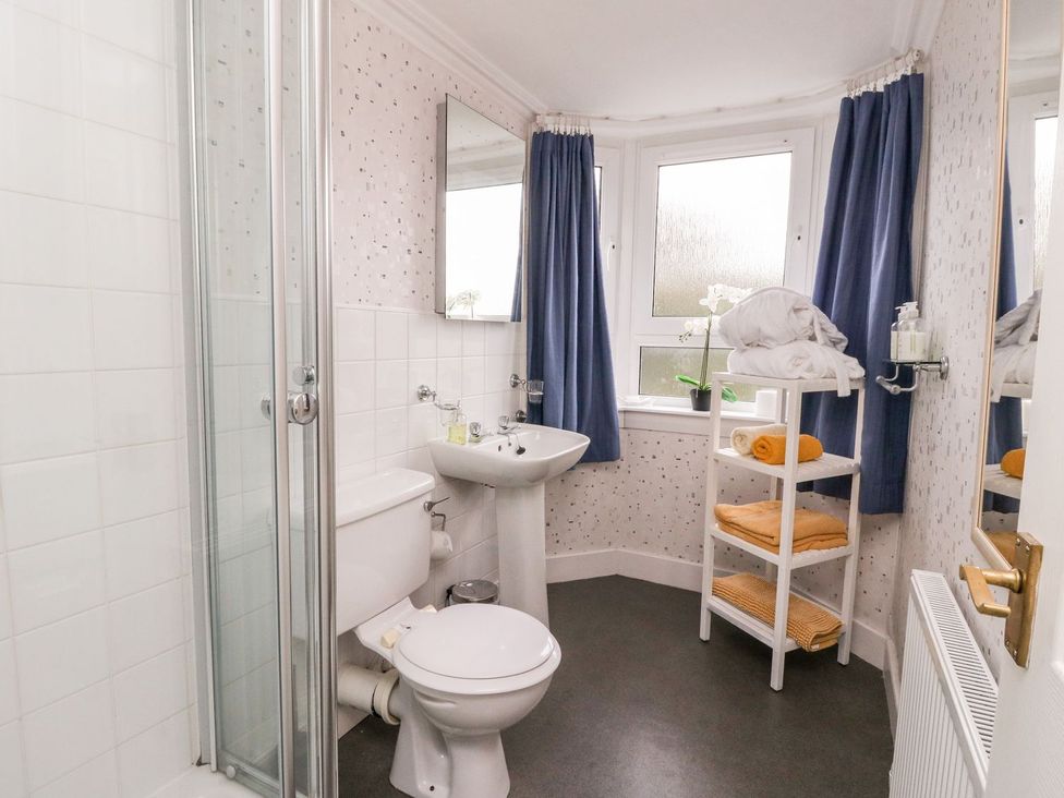 A bathroom with shower, toilet, sink and towel shelf at Seaview Wellness Retreat Carnoustie