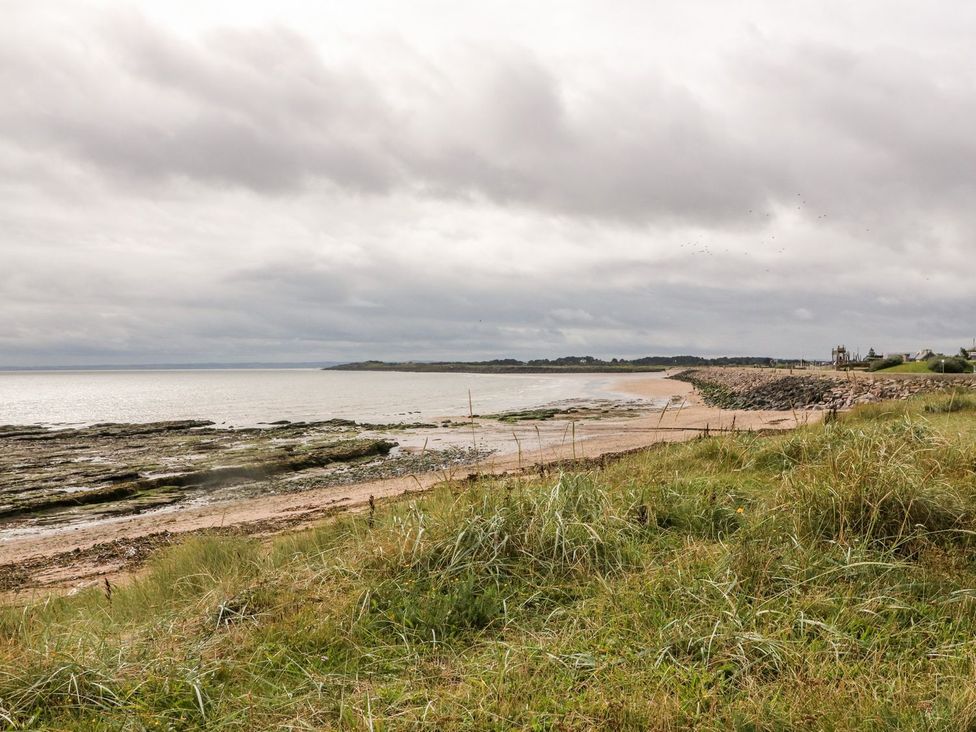 A beach with rocks and grass at Seaview Wellness Retreat in Carnoustie