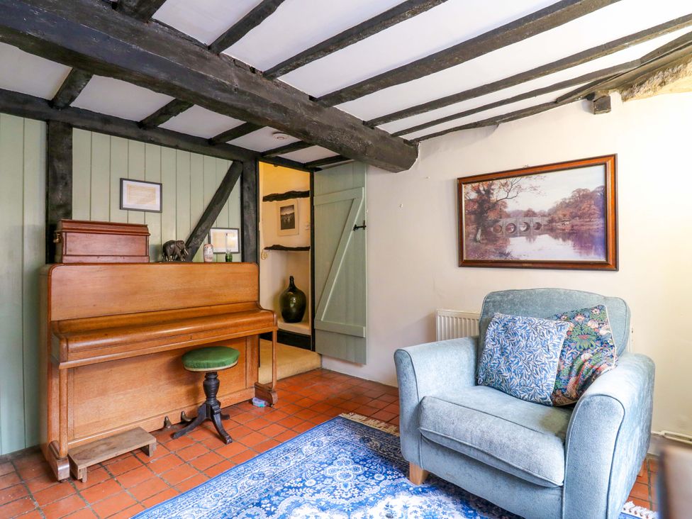 A snug with a piano and armchair at 118 High Street, Bedford