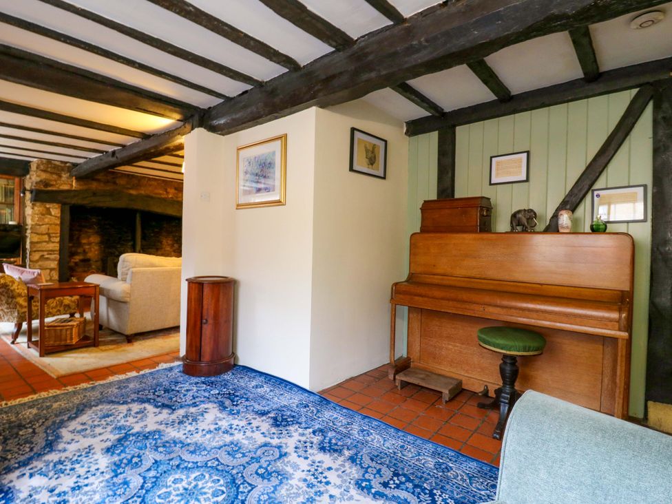 A living room with a piano and armchair at 118 High Street Bedford
