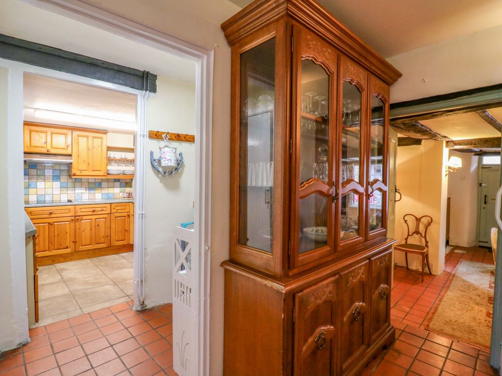 A hallway with a glass cabinet and entry to a kitchen at 118 High Street Bedford
