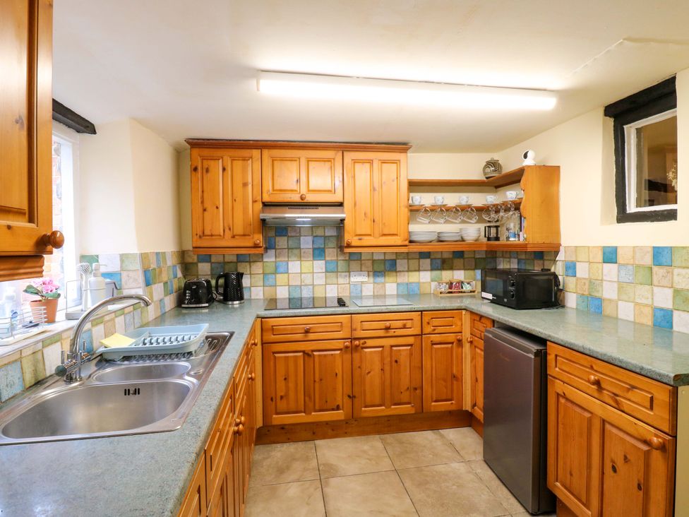 A kitchen with wooden cabinets and appliances at 118 High Street Bedford