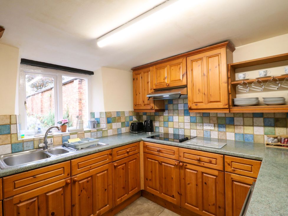 A kitchen with wooden cabinets and a sink at 118 High Street in Bedford