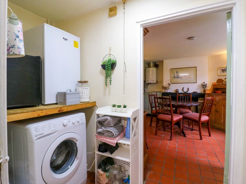 A laundry room with washing machine and refrigerator at 118 High Street in Bedford