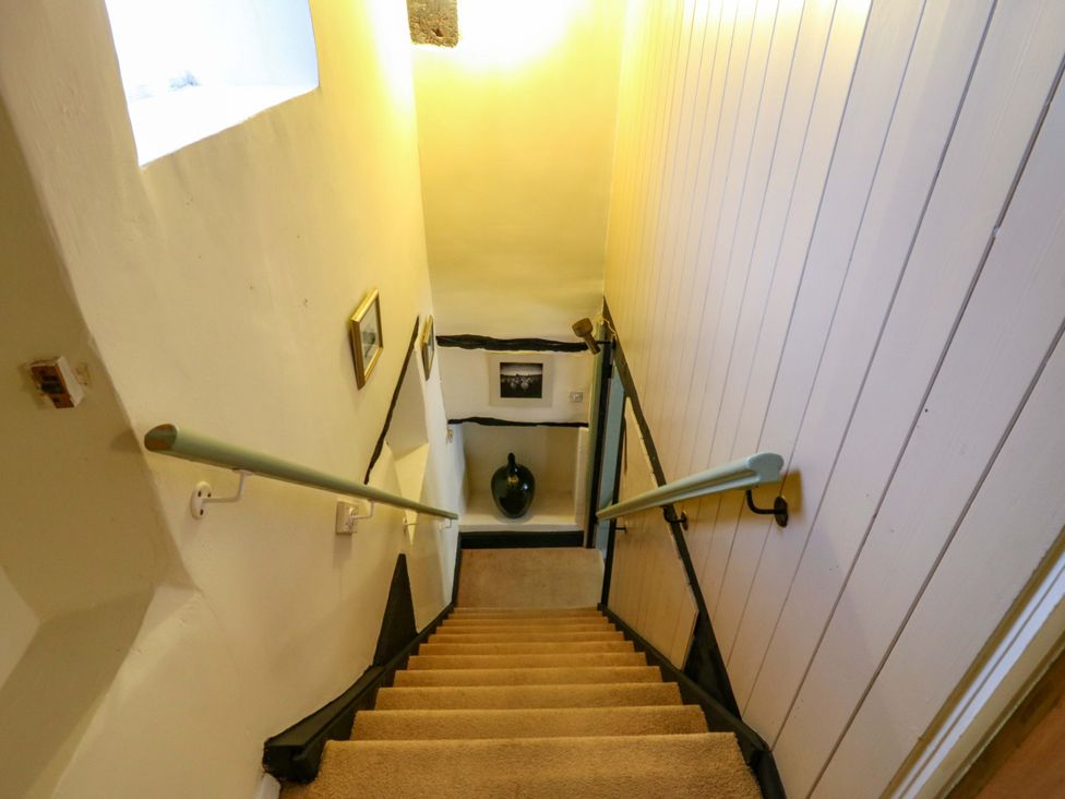 A staircase with a handrail and framed pictures at 118 High Street Bedford