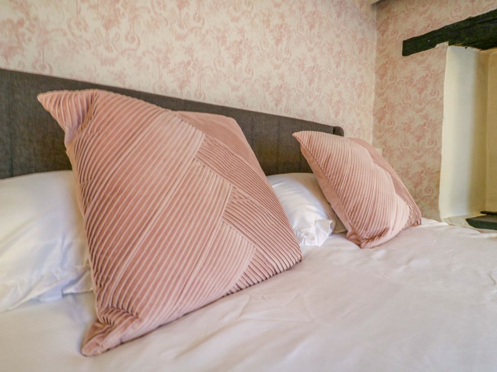 A bed with pink pillows in a bedroom at 118 High Street Bedford