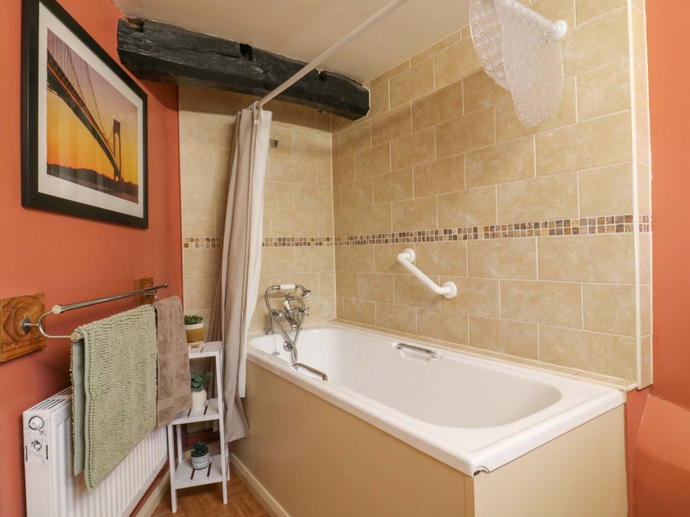 A bathroom with a bathtub and towels at 118 High Street, Bedford