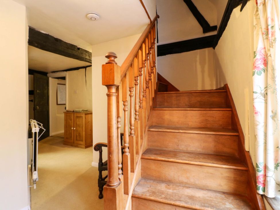 A staircase with wooden railings in a hallway at 118 High Street, Bedford