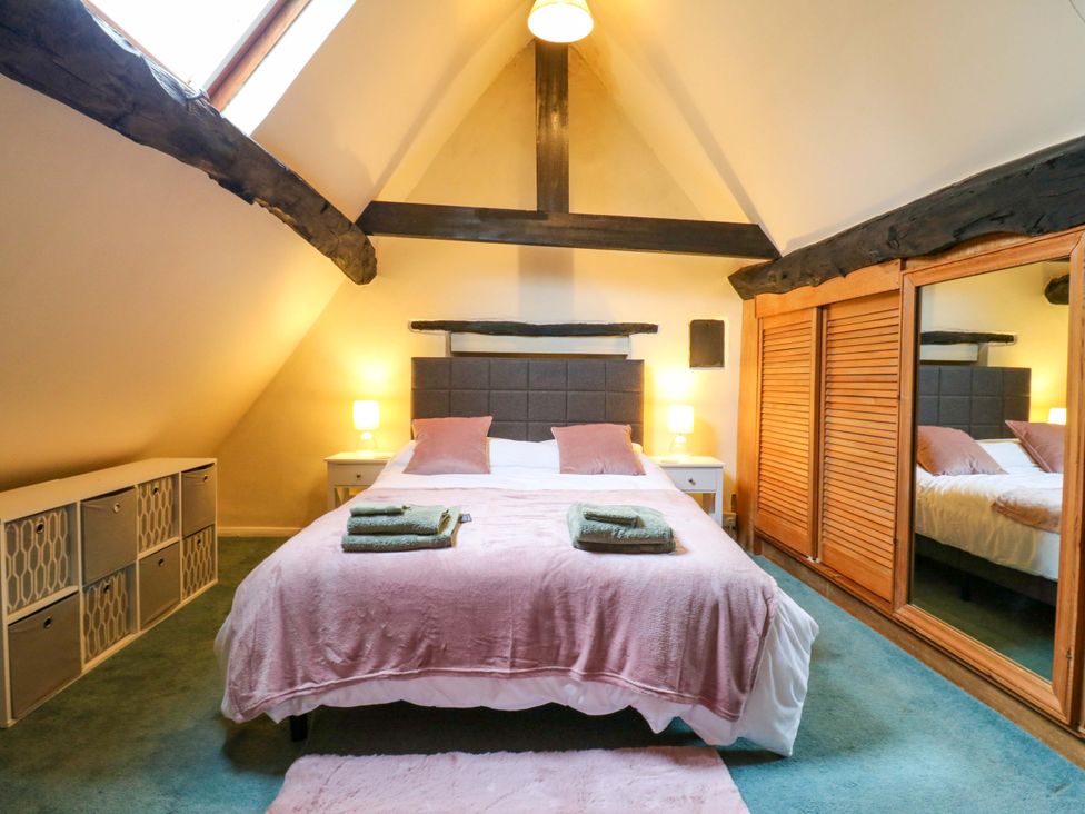 A bedroom with a bed and mirrored wardrobe at 118 High Street, Bedford