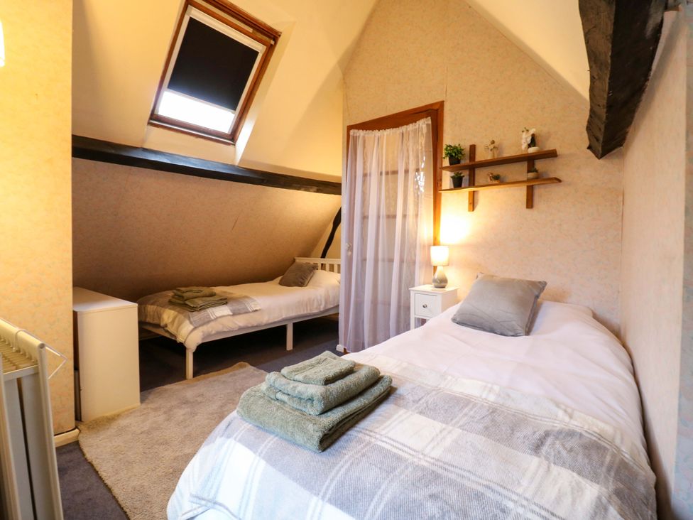 A bedroom with two beds and shelving at 118 High Street Bedford