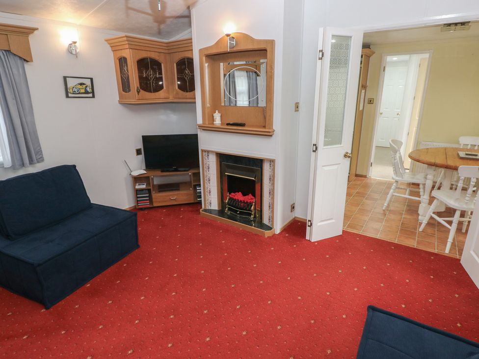 A living room with a television and fireplace at Static Caravan