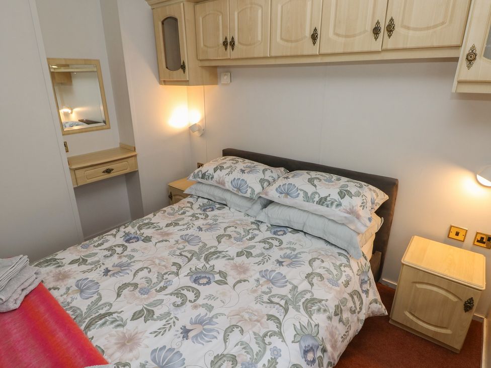A bedroom with a bed and furniture at Static Caravan