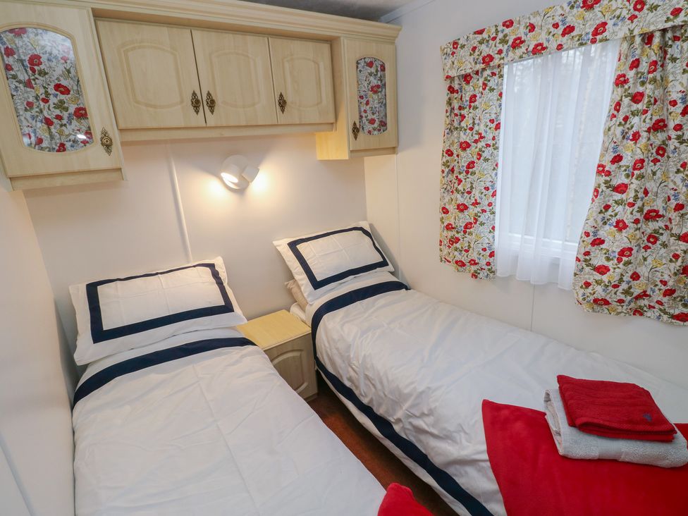 A bedroom with two beds and a wall cabinet at Static Caravan in 