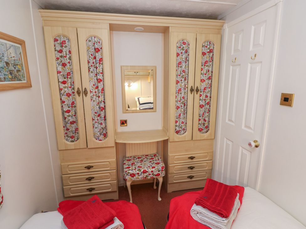 A bedroom with a wardrobe and mirror at Static Caravan