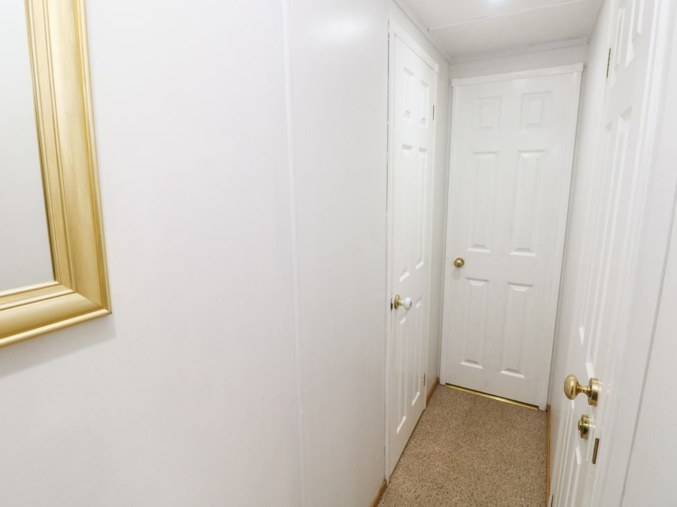 A hallway with doors and a mirror at the Static Caravan