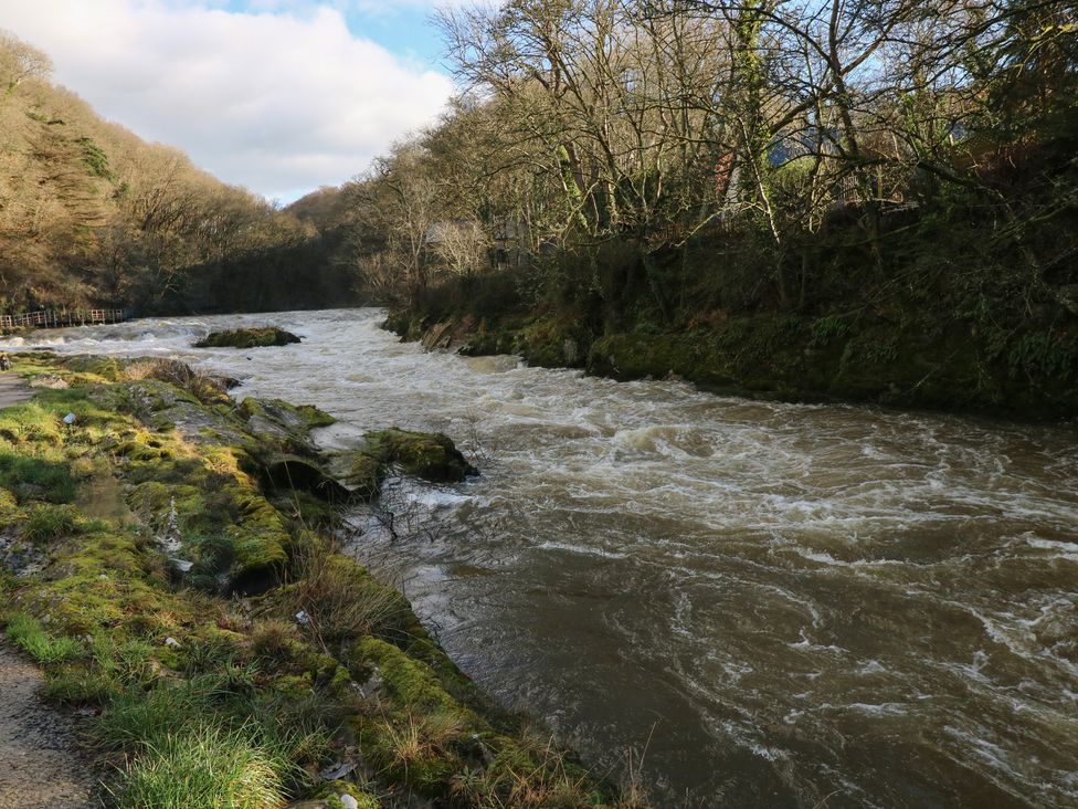 A river with flowing water and rocks beside it in a natural setting
