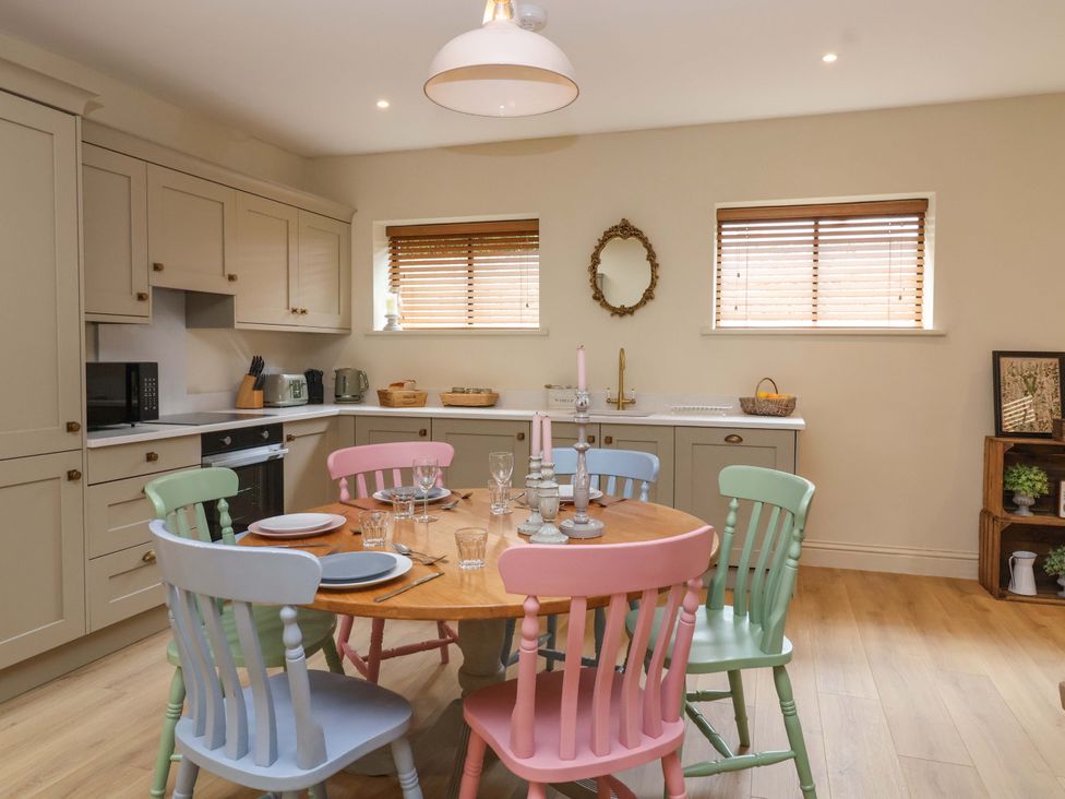 A kitchen with a dining table and colorful chairs at The Annex in Burford