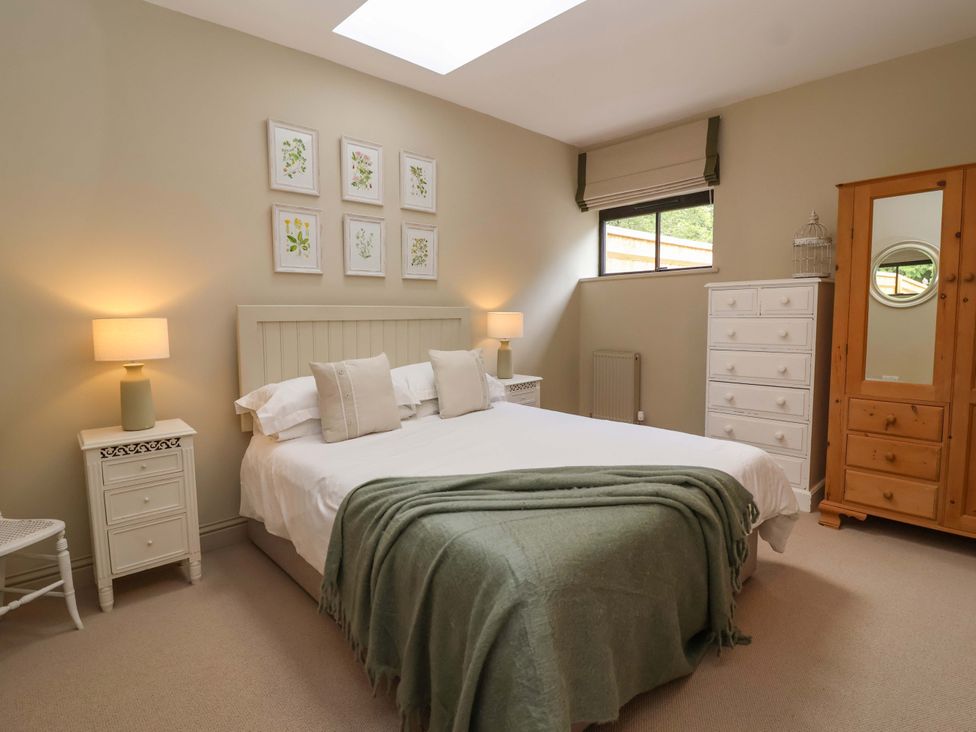 A bedroom with a bed and bedside tables at The Annex in Burford