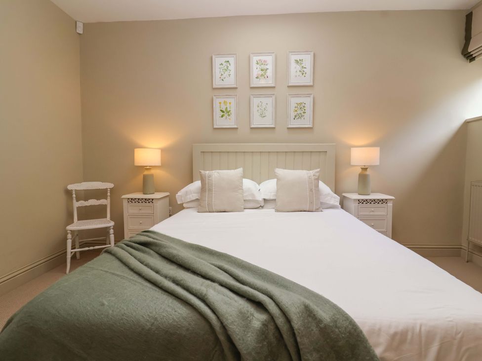 A bedroom with a bed, nightstands, and wall art at The Annex in Burford