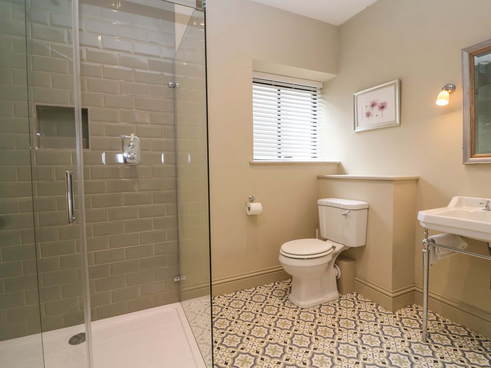 A bathroom with shower, toilet, and sink at The Annex in Burford
