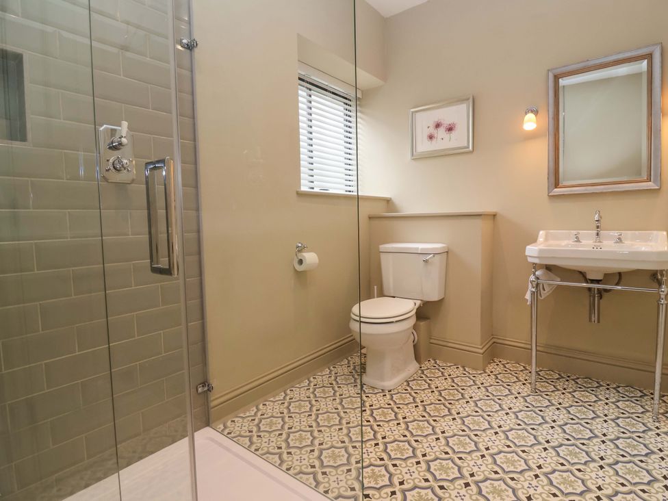 A bathroom with a shower, toilet, and sink at The Annex in Burford