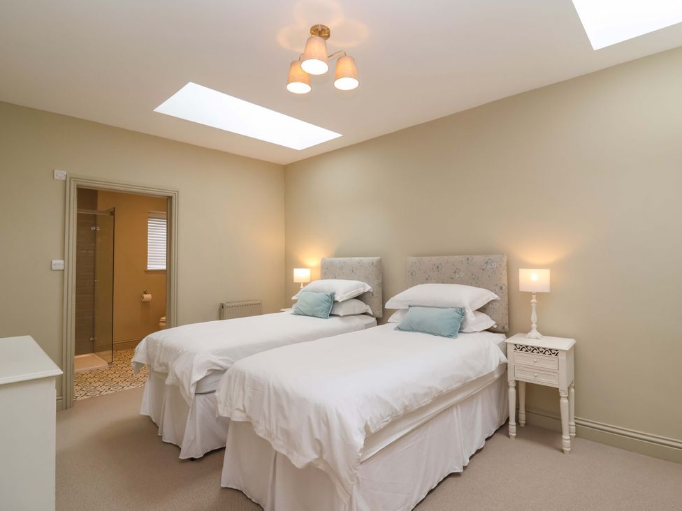 A bedroom with twin beds and a nightstand at The Annex in Burford