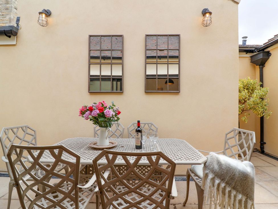 An outdoor patio with a table and chairs at The Annex in Burford