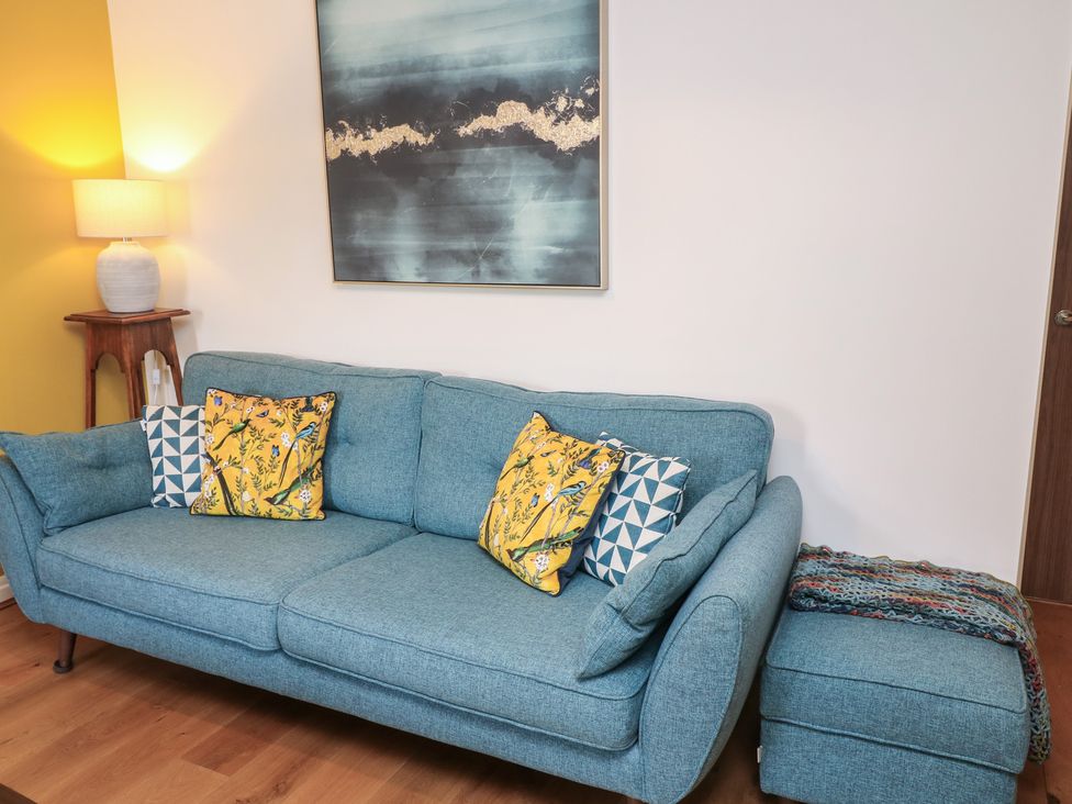 A living room with a blue sofa and cushions at No 39 Ashbourne