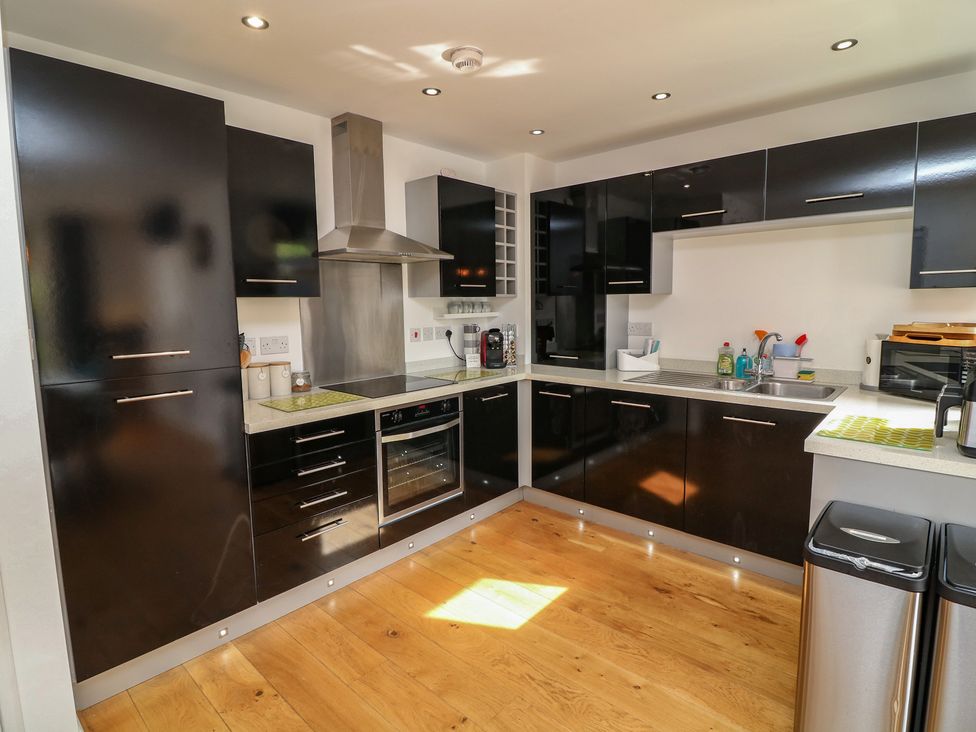 A kitchen with black cabinets and stainless steel appliances at No 39 Ashbourne