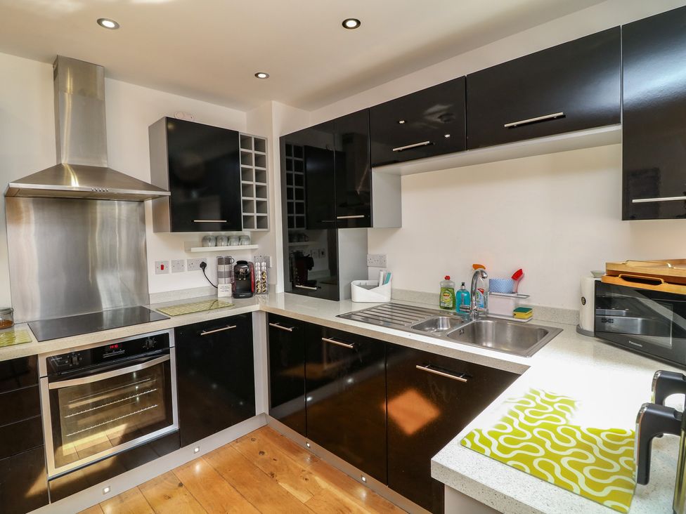 A kitchen with cabinets, stove, and sink at No 39 Ashbourne