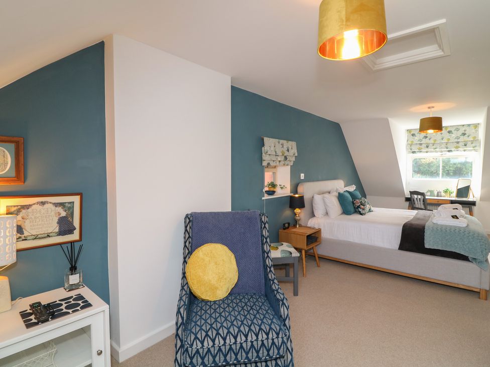 A bedroom with a bed, chair, and table at No 39 in Ashbourne