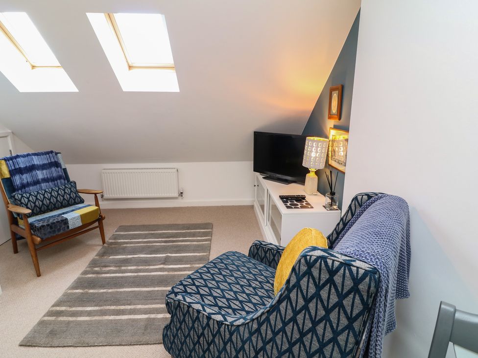 A living room with furniture including chairs and a television at No 39 Ashbourne