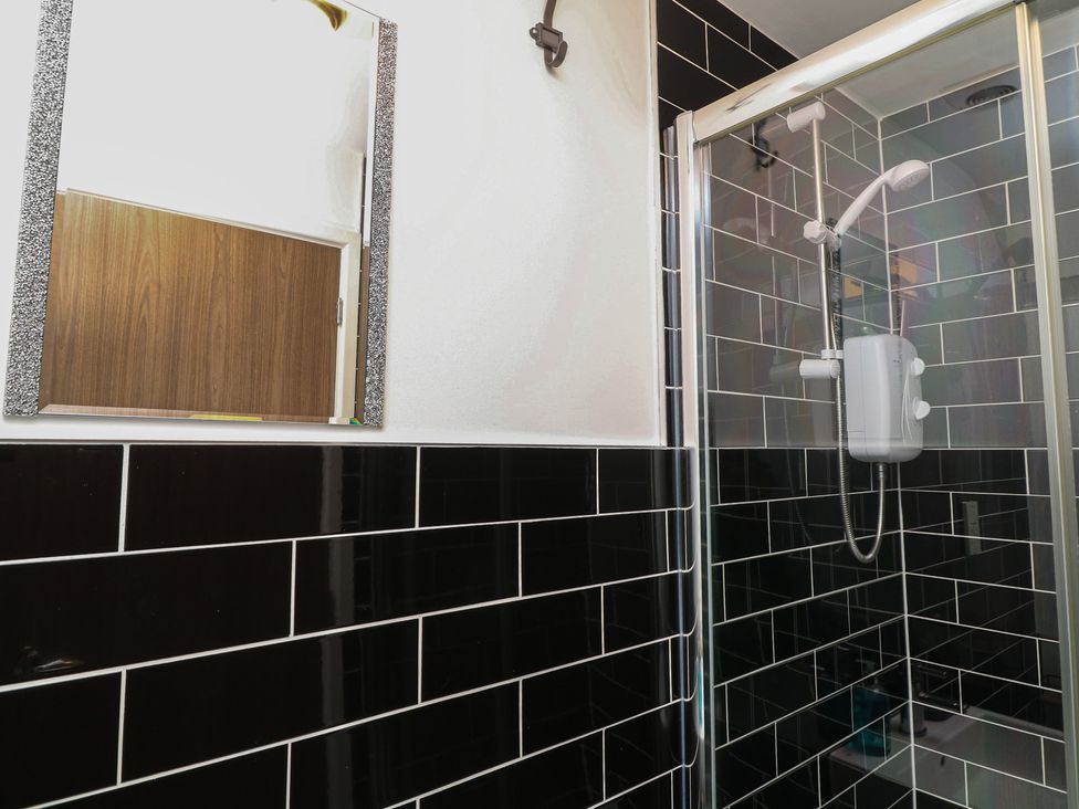 A bathroom with a shower and mirror at No 39 Ashbourne